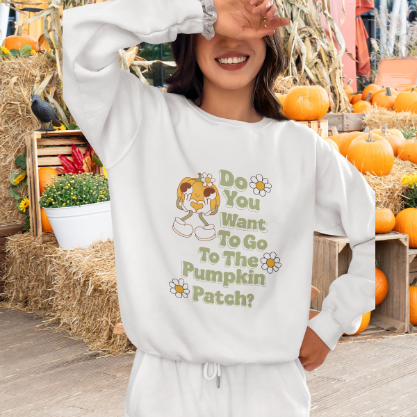 Woman at pumpkin patch wearing white Pumpkin Patch sweatshirt with retro cartoon and daisy design