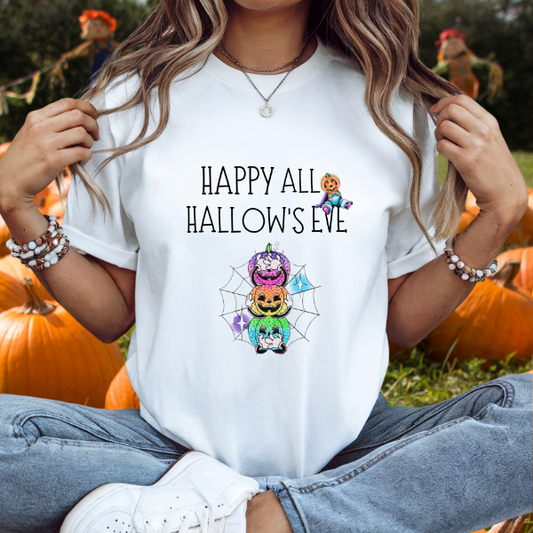 Woman wearing white All Hallow’s Eve shirt with colorful stacked jack o lanterns and spiderweb design at pumpkin patch