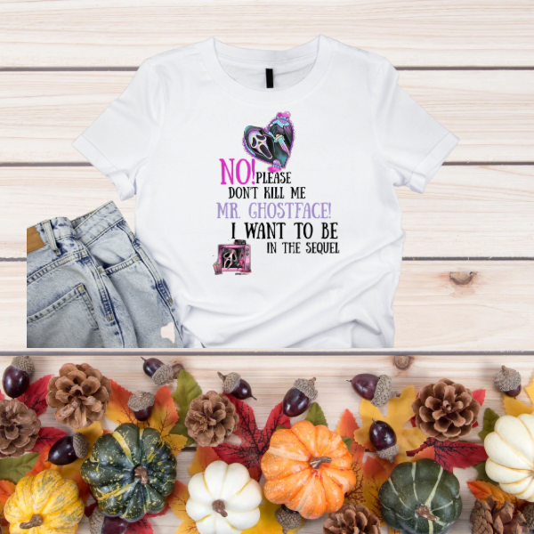 White Mr. Ghostface graphic t-shirt. Horror text and Ghostface mask print on flat lay with jeans and autumn decor